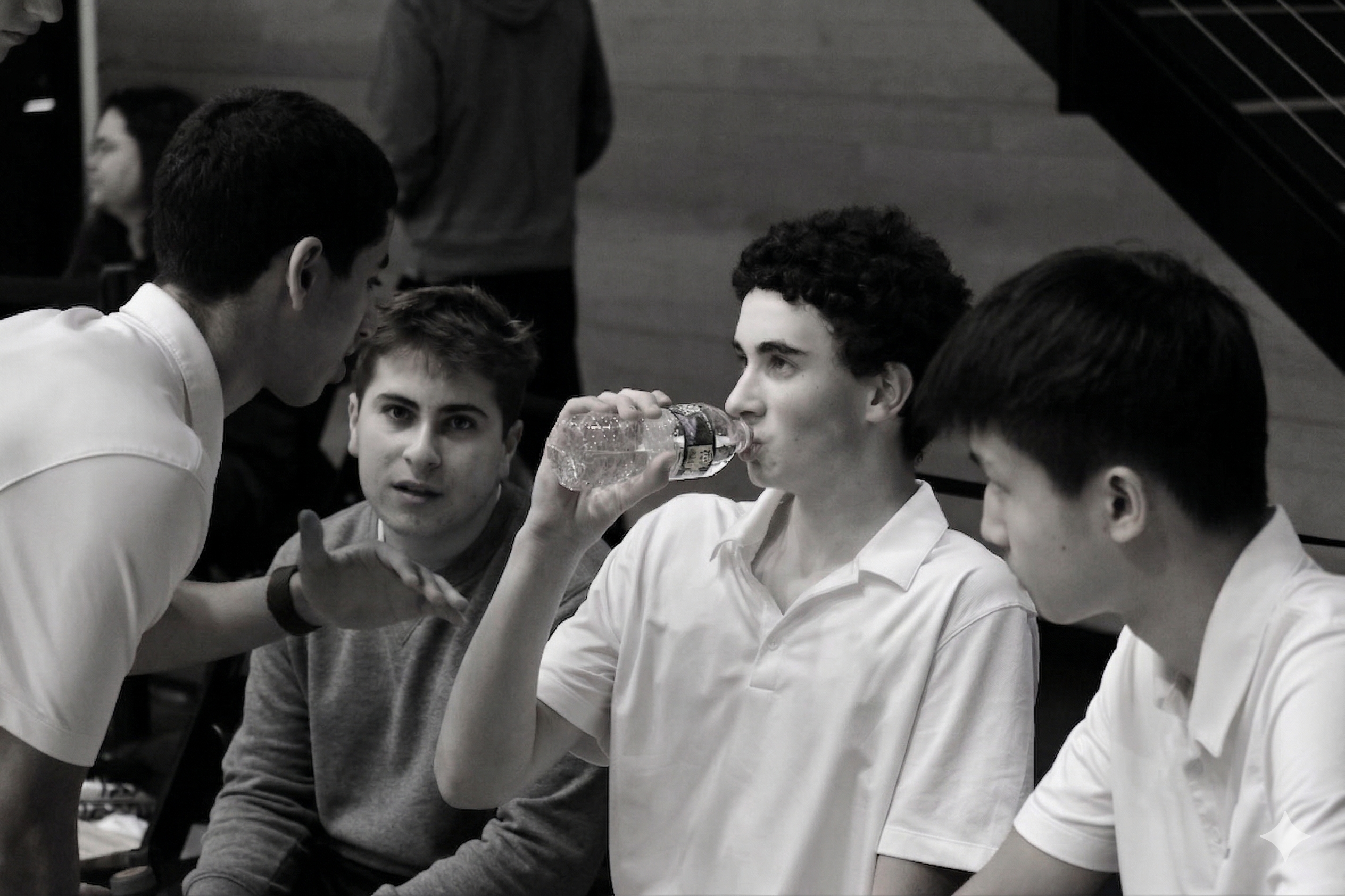 Three squash players receiving coaching courtside